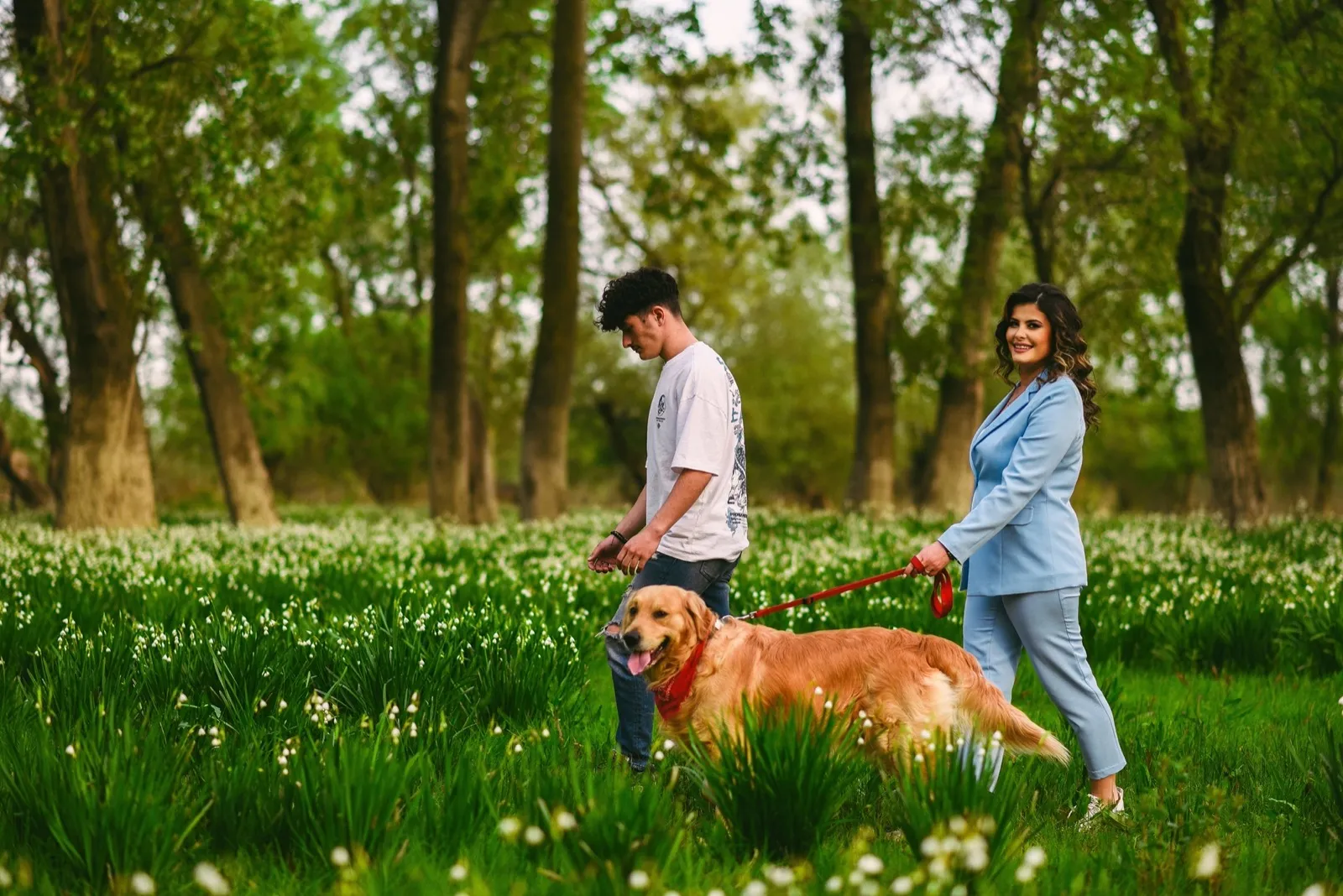 Familie mit Golden Retriever auf der Blumenwiese