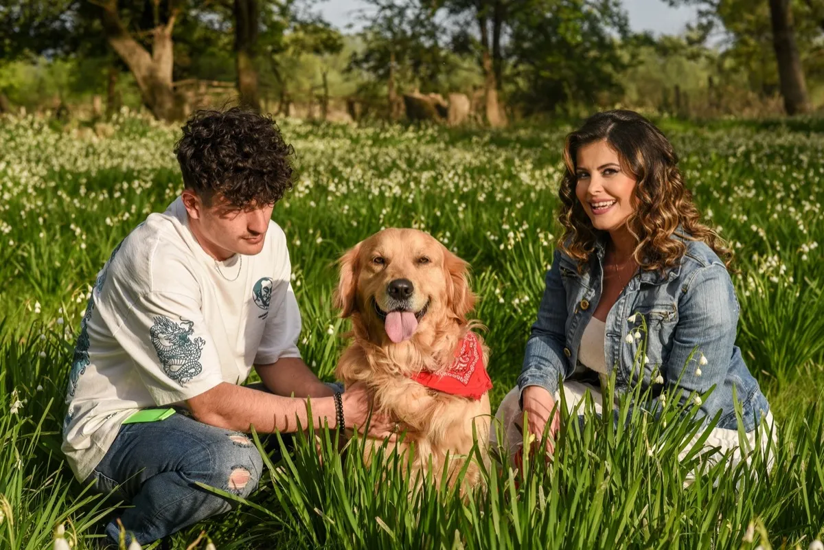 Junge mit Golden Retriever im Gras
